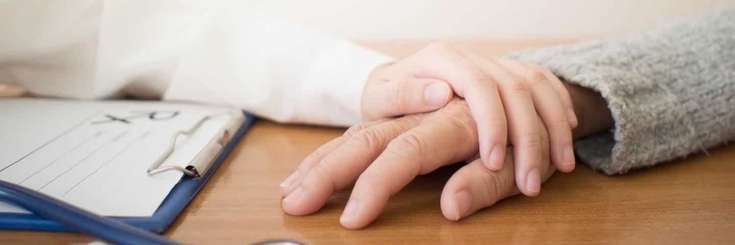 Doctor holding hand of patient