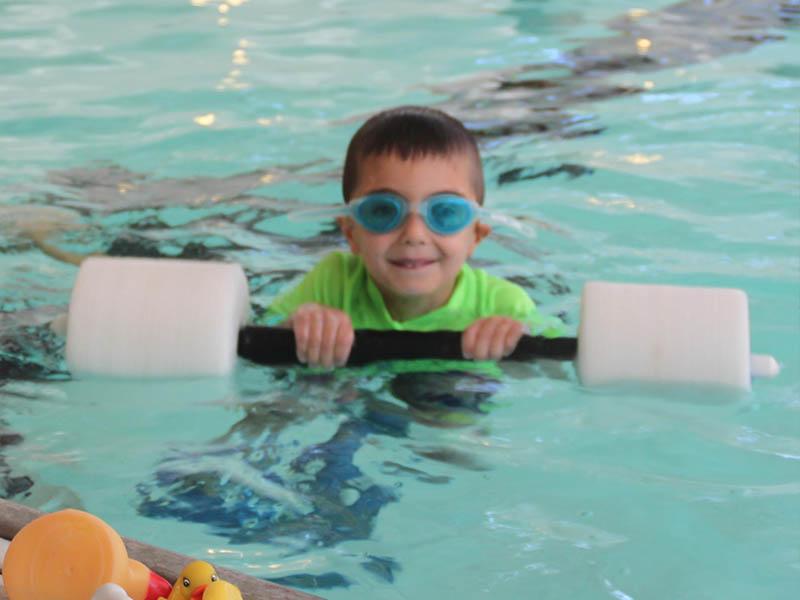 Boy holding a swim weight during swim lesson