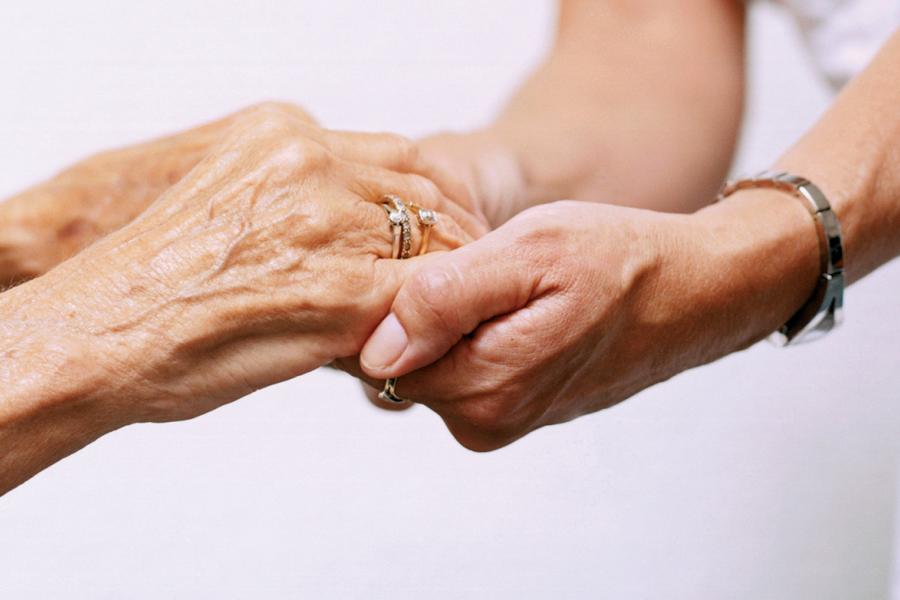 Patient holding hands with a nurse