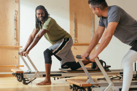 Two men on Pilates reformer