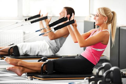 2 people sitting on Pilates Reformer